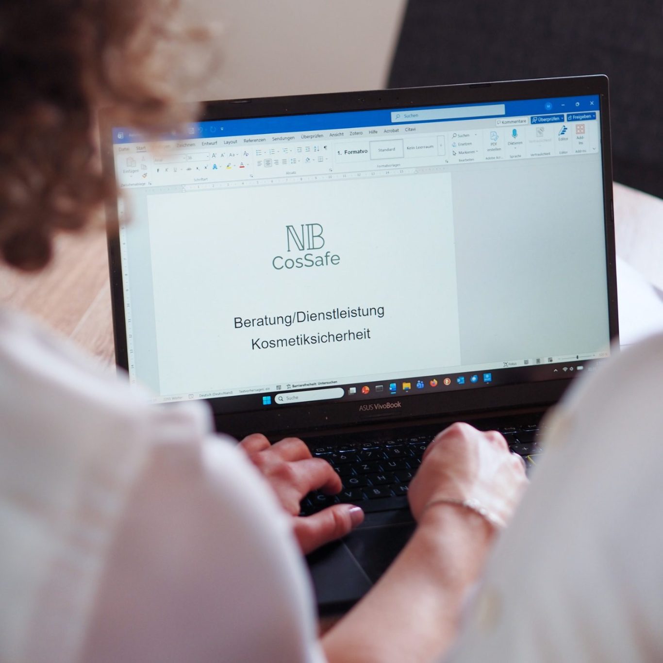 Person arbeitet an Laptop mit Dokument über Beratung und Dienstleistung Kosmetiksicherheit.